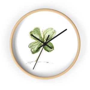 May include: A white clock with a wooden frame features a green four-leaf clover design.