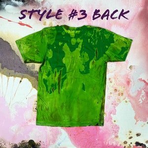 May include: Green t-shirt with a tie-dye pattern. The back of the shirt has a green, brown, and yellow pattern. "Style #3 Back" is written in purple on the top of the image.