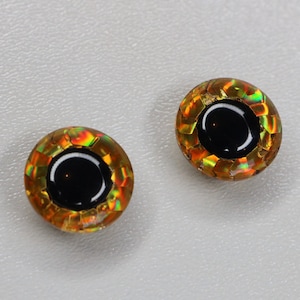 May include: Two gold and iridescent round fish eyes with black pupils.