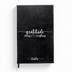 May include: Black leather-bound journal with the text "gratitude changes everything" and the name "Linda" embossed in white.
