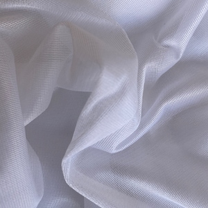 Op de afbeelding: Witte, doorschijnende stof met een fijne mesh-textuur. De stof is gedrapeerd en gevouwen, waardoor zachte plooien en bochten ontstaan.