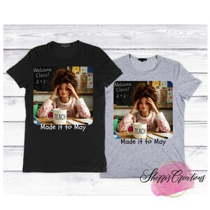 May include: Two t-shirts, one black and one gray, each featuring a graphic of a woman at a desk with a coffee mug that says "TEACH." The image includes the text "Welcome Class! 2+2= " and "Made it to May."