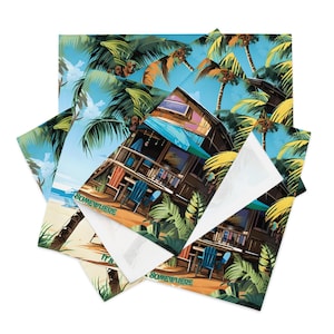 May include: A stack of square fabric napkins with a tropical beach scene. The design features a wooden beach house, palm trees, and the text "Somewhere". The color palette includes shades of blue, green, brown, and orange.