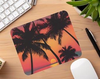 Pode incluir: Um tapete de rato com uma cena de pôr do sol com três palmeiras silhuetas contra um céu vibrante laranja, rosa e roxo. O sol se põe no horizonte, lançando um brilho quente na praia.