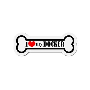 Puede incluir: Pegatina blanca en forma de hueso con contorno negro y el texto "I love my DOCKER" en letras negras con un corazón rojo entre "I" y "my".