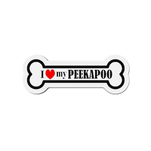 Può includere: Adesivo bianco a forma di osso con contorno nero e il testo "I ♥ my PEEKAPOO" in nero. Un cuore rosso sostituisce la parola "love".