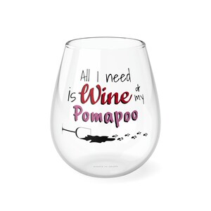 Pode incluir: Uma taça de vinho de vidro transparente com o texto "All I need is Wine & my Pomopoo" impresso nela. O texto está em vermelho e rosa com uma silhueta preta de uma taça de vinho derramando vinho e pegadas.