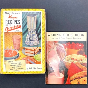 May include: Two vintage cookbooks with colorful covers. The book on the left is titled "Mary Meade's Magic Recipes for the Osterizer" and features a blender and various food items. The book on the right is titled "Waring Cook Book for the 8 Push Button Blender" and features a blender pouring a pink liquid into a glass.