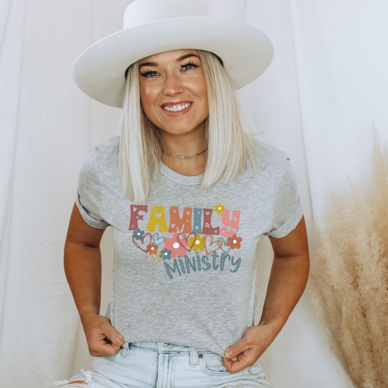 May include: A gray t-shirt with the text "FAMILY MINISTRY" in colorful letters with hearts and flowers around the text.