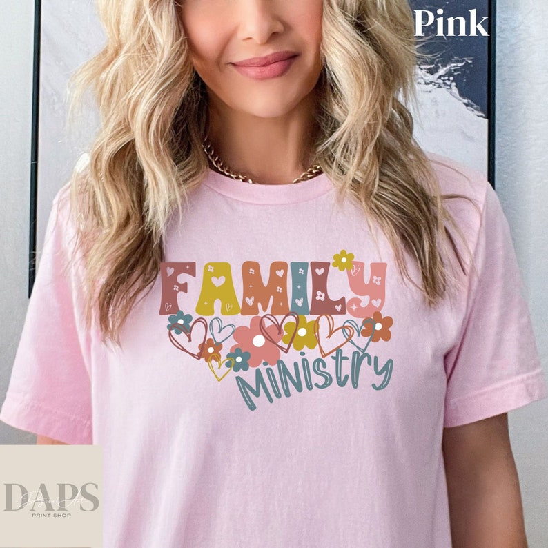 May include: Pink t-shirt with the text "Family Ministry" in colorful letters with hearts and flowers around the text.