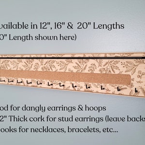 Wall mounted jewelry organizer made of solid maple wood and engraved with a floral pattern. There is a black steel bar for earrings to hang on, a cork insert for stud earrings and a series of hooks for necklaces and other accessories.