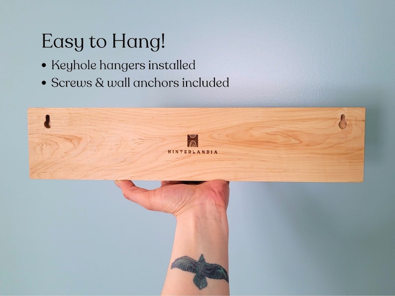 Back of wood jewelry hanger showing two keyhole hangers and the company logo.