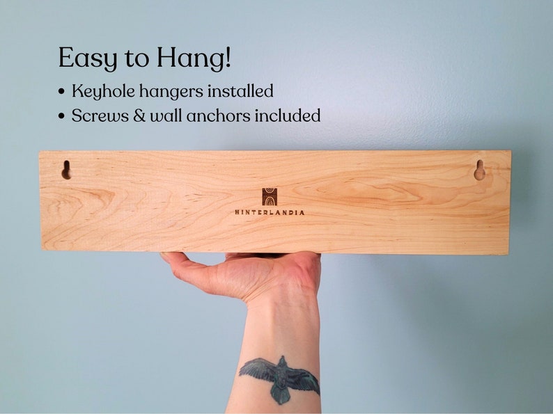Back of jewelry holder showing two keyhole hangers and the Hinterlandia company logo.
