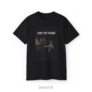 Puede incluir: Camiseta negra con un estampado gráfico de una persona en una habitación oscura con el texto "CRY OF FEAR" encima.