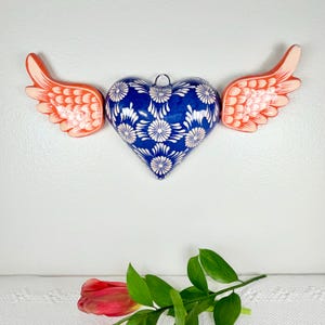 May include: A white ceramic mug with a black handle and the text "But First, Coffee" in a black, bold font. The mug is on a white surface. The mug is approximately 4 inches tall.