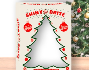 Könnte beinhalten: Eine Vintage-Box für Shiny Brite Weihnachtsbaumschmuck aus Glas. Die Box ist cremefarben mit roten und grünen Akzenten. Sie zeigt einen großen grünen Weihnachtsbaum mit einem Ausschnitt für ein Foto. Die Box trägt den Text "Shiny Brite" in roten Buchstaben und "Happy New Year" auf zwei Ornamenten.
