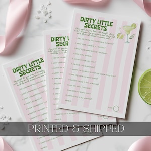 May include: Three rectangular game cards titled Dirty Little Secrets with pink and white vertical stripes. The cards feature twelve numbered questions in dark green text, a margarita illustration, and a score circle at the bottom right corner.