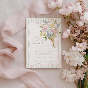 Peut inclure: Une invitation &agrave; une f&ecirc;te pr&eacute;nuptiale avec une illustration de bouquet floral. L'invitation pr&eacute;sente le texte "She's fresh off the market" et les d&eacute;tails de l'&eacute;v&eacute;nement. Le design comprend un code couleur vert clair et rose, avec un ruban et des fleurs.