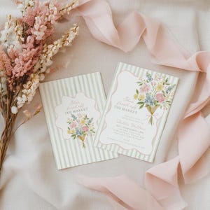 Peut inclure: Deux cartons d'invitation sur le th&egrave;me floral avec le texte "She's fresh off the market". Les cartes pr&eacute;sentent un bouquet de fleurs aux couleurs pastel sur un fond ray&eacute;. Un bouquet de fleurs roses et blanches et un ruban rose sont en arri&egrave;re-plan.