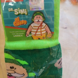 May include: Green and dark green socks featuring a cartoon character with a white mustache, wearing a green hat and striped shirt. The packaging includes the text "CALCETIN" and "DR. SIMI El Chavo". The socks are labeled "UNISEX".