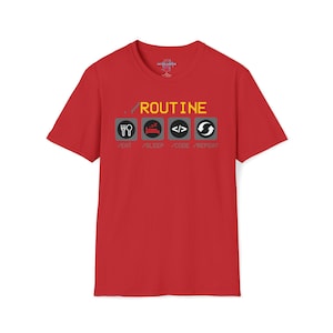 May include: Red t-shirt featuring a graphic design. The design includes the word "ROUTINE" in yellow, and four icons: a fork and knife, a bed, code brackets, and a circular arrow, with the words "EAT", "SLEEP", "CODE", and "REPEAT" below each icon.