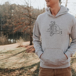 May include: A gray hooded sweatshirt with a black graphic of a hand with smaller hands forming the word "DAD".