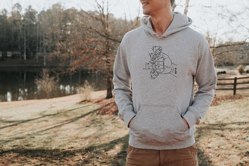 May include: A gray hooded sweatshirt with a black graphic of a hand with smaller hands forming the word "DAD".
