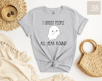 Peut inclure: Un t-shirt gris avec un motif de fantôme et le texte "I ghost people all year round".