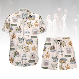 Könnte beinhalten: Cremefarbenes zweiteiliges Set, bestehend aus einem kurzärmeligen Hemd und Shorts, beide mit Illustrationen und Text aus dem Musical "Hamilton" bedruckt. Die Shorts haben einen Kordelzug in der Taille. Das Hemd hat eine Knopfleiste.