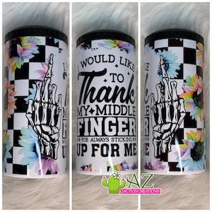 May include: A white tumbler with a black lid features a black and white checkered pattern, floral accents, and a skeleton hand giving the middle finger. Text reads "I would like to thank my middle finger for always sticking up for me."