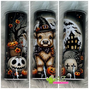 May include: A Halloween-themed tumbler featuring a cartoon calf wearing a witch hat and scarf. The design includes pumpkins, a haunted house, bats, and a full moon against a black background. The tumbler has a silver rim and a black lid.