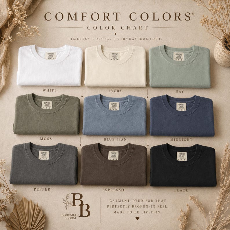 K&ouml;nnte beinhalten: Eine Comfort Colors Farbkarte mit neun gefalteten T-Shirts mit Rundhalsausschnitt in Wei&szlig;, Elfenbein, Bay, Moos, Blue Jean, Midnight, Pepper, Espresso und Schwarz. Jedes T-Shirt hat ein sichtbares Innenetikett mit dem Markennamen Comfort Colors.