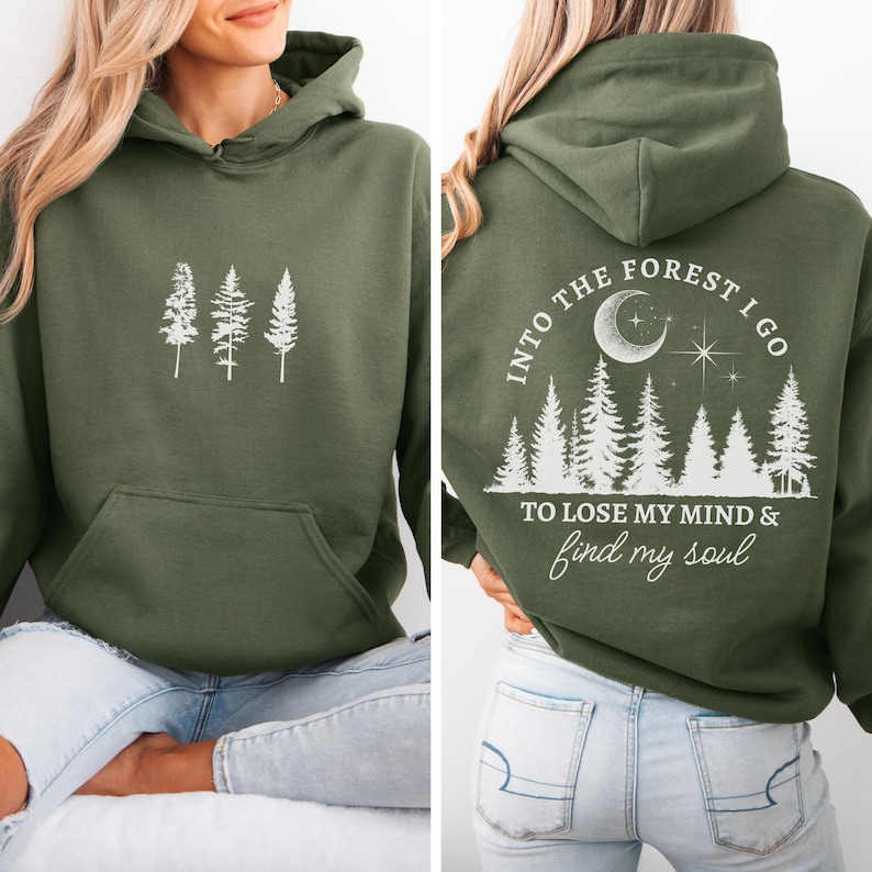May include: A green hooded sweatshirt with a white graphic on the front of three trees and a white graphic on the back that says "Into the forest I go to lose my mind & find my soul" with a crescent moon, stars, and trees.