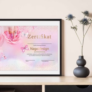 Könnte beinhalten: Ein rosa und weißes Zertifikat mit goldener Umrandung und dem Text "Zertifikat" und "Nageldesign" in goldenen Lettern. Das Zertifikat ist mit einer rosa Rose und Schmetterlingen verziert.