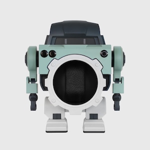 May include: A robot-like watch display case in shades of teal, gray, and white. The case has a large circular opening in the center, with articulated arms and legs. The top section is a darker gray, resembling a cockpit.