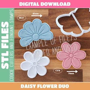 Pode incluir: Um conjunto de cortadores e carimbos de biscoito em forma de margarida, incluindo uma flor azul, uma branca e uma rosa. A imagem exibe o texto DIGITAL DOWNLOAD, STL FILES e DAISY FLOWER DUO, com etiquetas de 85mm e 70mm.