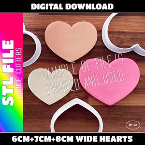 May include: Three heart-shaped cookie cutters in different sizes, 6 cm, 7 cm, and 8 cm wide. The cutters are made of white plastic and are shown on a wooden surface. The text "EXAMPLE OF FILE/S PRINTED AND USED" is visible in the image.
