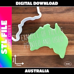 May include: A green plastic cookie cutter shaped like the continent of Australia. The cutter is 70mm tall and 75mm wide. The text "EXAMPLE OF FILE/S PRINTED AND USED" is printed on the cutter. The text "AUSTRALIA" is printed below the cutter. The text "A526" is printed in a white circle on the right side of the image.