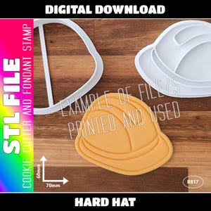 May include: White plastic cookie cutter in the shape of a hard hat. The cutter is 7 cm wide and 6 cm tall. An example of the cutter is shown with a yellow fondant cookie.