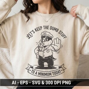 Può includere: Felpa beige con grafica in bianco e nero di un tasso in uniforme da poliziotto, che fischia e fa un gesto di stop. Il testo recita "LET'S KEEP THE DUMB STUFF TO A MINIMUM TODAY."