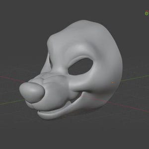 Pode incluir: Uma máscara canina cinza claro renderizada em 3D, com um focinho arredondado, órbitas oculares abertas e uma boca ligeiramente aberta. A máscara está sobre um fundo de grade cinza escuro, sugerindo um design ou modelo digital.