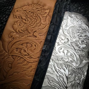 May include: Close-up of two leather panels with an embossed tiger design. The panel on the left is brown and the panel on the right is silver.