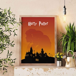 Peut inclure: Une affiche encadrée avec une silhouette du château de Poudlard et deux personnages devant un coucher de soleil orange. Le texte "Harry Potter" est en haut de l'affiche.