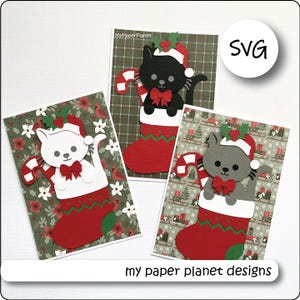 Peut inclure: Trois cartes de vœux artisanales avec des découpes en papier superposées représentant des chats dans des chaussettes de Noël. Chaque chat porte un bonnet de Père Noël et un nœud rouge, tenant un sucre d'orge. Motifs de fêtes et texte MyPaperPlanet.