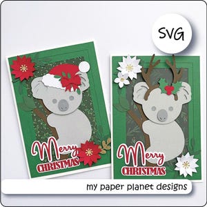 May include: Two Christmas cards featuring koala bear designs. One koala wears a Santa hat, the other has antlers. Both cards have a green background with the words "Merry Christmas" in red. The cards are decorated with red and white flowers.