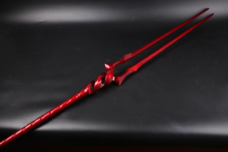 May include: A red metal spear with a twisted handle and a double-pronged tip.