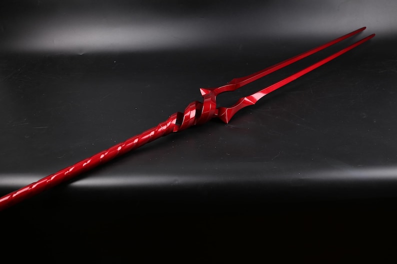 May include: A red, twisted, metal spear with a double-pronged tip.