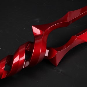 May include: A red metal sword with a twisted handle. The sword has a sharp point and a double-edged blade.