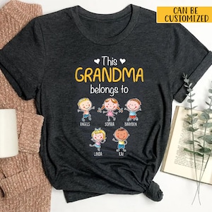 May include: A dark grey t-shirt with the text "This Grandma belongs to" and five cartoon children with names below them: Engels, Sophia, Brayden, Linda, and Kai.