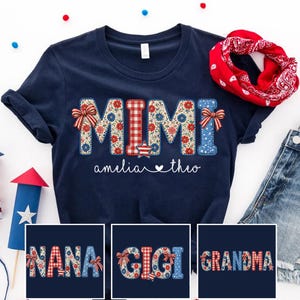 May include: Navy blue t-shirt with the word "MIMI" in a floral and gingham pattern, with the names "amelia" and "theo" below. Additional shirts display "NANA", "GIGI", and "GRANDMA". A red bandana and a firework are also visible.